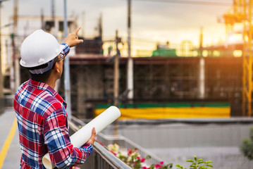 Close up engineers holding a blueprints working on a building site