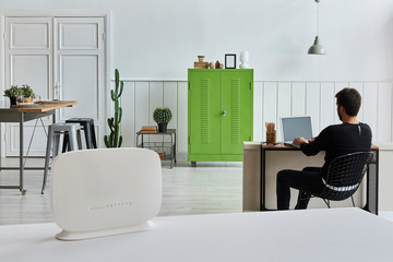 Router and Modem internet box close up and on the white table. Modern home background. Internet is...