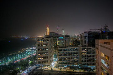 Fototapeta na wymiar High shot of Abu Dhabi city towers and skyline at night - Corniche view