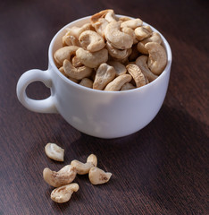 nuts in white  bowl on wooden background