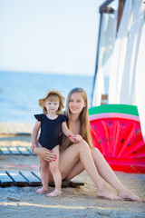 Fototapeta na wymiar Happy family lifestyle. Relaxing and enjoying life. Bright colors. Top view Young mother with cute daughter Summer travel, water sport outdoor activities, posing on tropical beach holiday