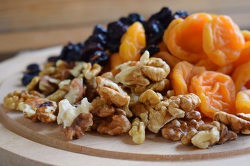 Useful dried fruits and walnuts on wooden background.