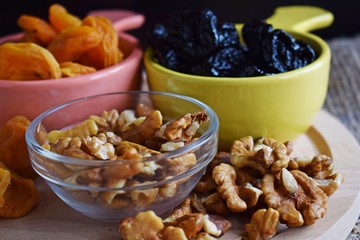 Useful dried fruits and walnuts on wooden background and burlap.