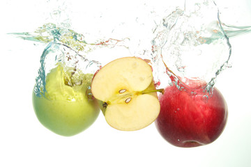 Apples red and green and aple slice splash in water on white