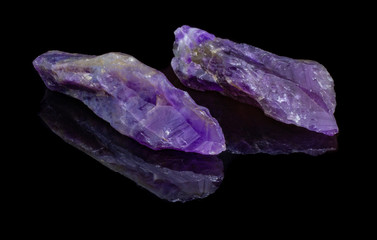 Two natural untreated crystals amethyst on a black background