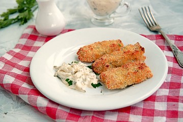 Homemade fish sticks baked under the grill in the oven. Served with tartar sauce of mayonnaise and grated pickled cucumber.