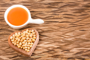 Soy bean and soy oil on wooden table - Glycine max