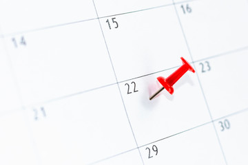 Pin on 22 date. Twenty two day of month is marked with red thumbtack on calendar. Save the Date concept.