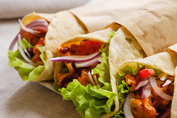 Mexican burrito with chicken, pepper and beans close up