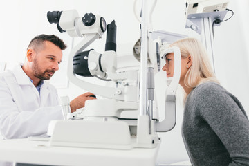 Fototapeta na wymiar Optician checking woman's eyes with special equipment.