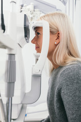 Woman taking eyesight test at optician's office.