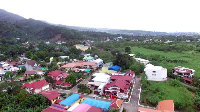 Los Ba&ntilde;os, Laguna, Philippines - November 21, 2017: Modern housing community at the foot of mountain rainforest. Drone Aerial Shot