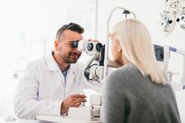 Optician examining woman's eyes with a machine.