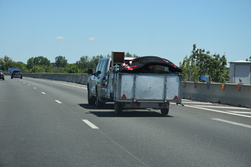 Remorque chargée tirée par une voiture sur l'autoroute A9 languedocienne dans l'Hérault
