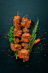 Skewers of barbecue sauce. On a wooden background. Top view. Free space for your text.