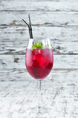 Flamingo Cocktail. Liquor currants, blackberries and mint. Alcoholic cocktail in a glass. On a wooden background. Top view. Free copy space.