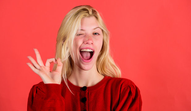 Things gonna be alright. Girl wink happy face while show ok gesture over red background. Woman satisfied with everything. Everything is ok or fine. Alright concept. Alright gesture body language