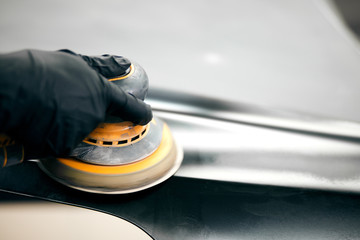 mechanic worker repairman sanding polishing car and preparing automobile for painting