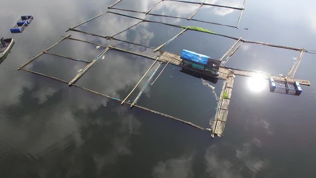Sampaloc Lake, San Pablo City, Laguna, Philippines - November 12, 2017: Bamboo fish cages built in the middle of mountain lake. Drone aerial shot