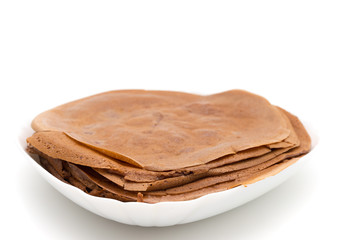 Chocolate pancake on a white plate on a white background
