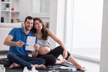 pregnant couple checking a list of things for their unborn baby