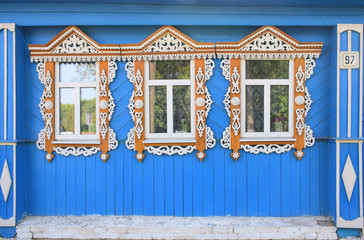 Carved platbands on the windows as the decor of a wooden old house in Suzdal. Russia, Suzdal, August 2017.