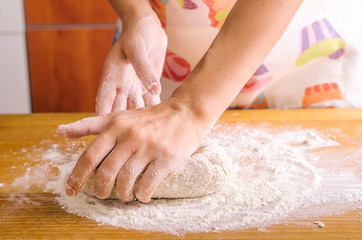 Woman's hands kneading the dough