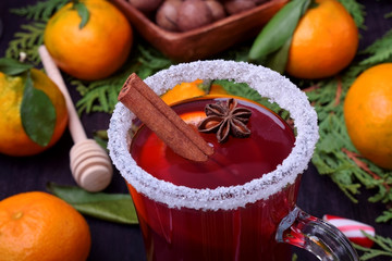 Hot mulled wine with slices of citrus fruits, cinnamon and anise in an Irish glass decorated with sugar border