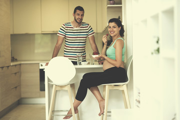 couple eating fruit strawberries at kitchen