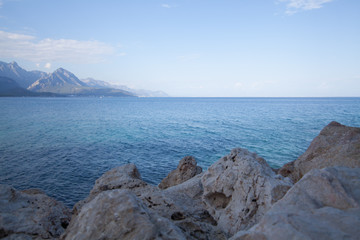  Rocks and a calm blue sea against the background of mountains. Landscape photo concept for screen savers and Wallpapers.