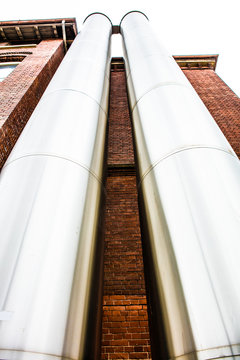 Low ngle of Two Steel tubes running outside Building.