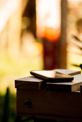 Celular posado en un banco con reflejos.