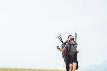 Close-up of a professional paraglider holding brakes and looking away. Paraglider sport concept