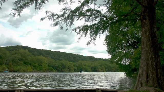 4K speedboat crossing right to left on Austin's Lake Travis under a blue but cloudy sky on a beautiful Labor Day weekend