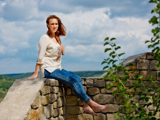 Fototapeta premium Beautiful young girl with red hair posing against nature background.