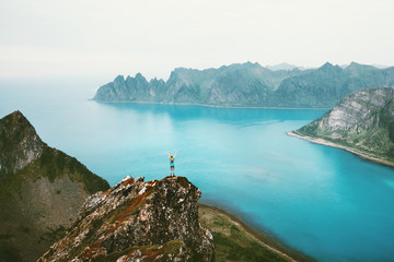 Norway vacations woman standing alone on cliff mountain edge above sea travel adventure lifestyle...