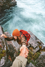 Travel couple helping hand holding together on rocks over river man and woman family adventure lifestyle vacations outdoor exploring wilderness