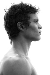 Profile portrait of a fit, bare-chested man with black hair and strong features