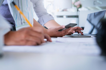Close up of civil male engineer asian working on blueprint architectural project at construction site at desk in office.