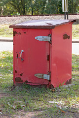 Fototapeta na wymiar A Close up side view of a red old rusted post offcie post box storage unit