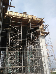 Fototapeta na wymiar Metal scaffolding installed by construction workers at the construction site. It is used as temporary support structure and as the platform for workers to work on it. 