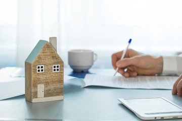 The real estate agent signs the transaction documentation while sitting at the desk. Buying a home. Mortgage.
