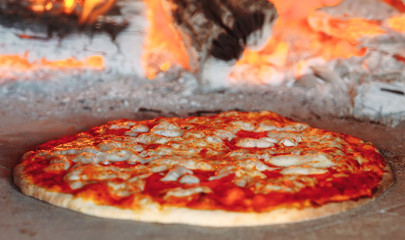 Brick oven with hot pizza cooking inside.