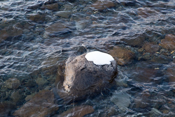 Sunset light at Lake Shikotsu near Yamasentetsu Bridge with snow ground and water in winter season.