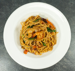 Spaghetti spicy shrimp seafood in a white dish on table,food concept, Close up..
