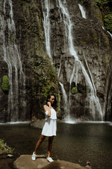 stylish young woman taking picture for social media in waterfall