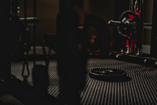 Weight plate on the floor in the gym with low light