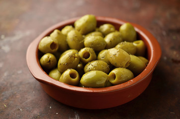 Green olives in clay bowl