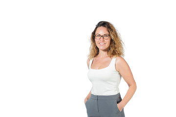 Fototapeta premium business woman in white shirt and gray pants on a white background. beautiful girl in glasses holds hands in pants, looking at camera . isolated on background, copy space.