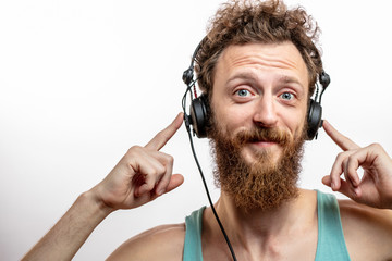 Funny carefree hippy DJ in casual wear, with phone headset wearing fair beared on cheerful smiling...